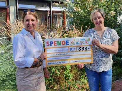 Das Foto zeigt Claudia Baumg&auml;rtner (l.) und Bianca Heins bei der Spenden&uuml;bergabe im Au&szlig;enbereich des Kinderhospizes.