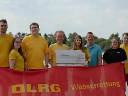 Freuen sich &uuml;ber die Spende: FDP-Ortsverbandsvorsitzender Eike Brakmann (blaues Polo-Shirt) &uuml;berreicht Vertretern des DLRG-Vorstandes den symbolischen Scheck.
