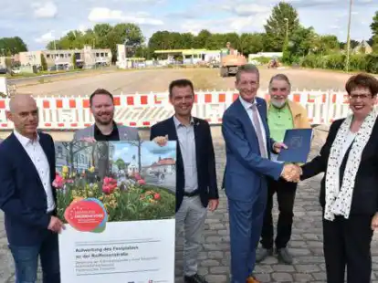 Die erste F&ouml;rderung aus dem Sofortprogramm &bdquo;Perspektive Innenstadt!&ldquo; flie&szlig;t: (von links) Henning Kahl (Fachdienstleiter Tiefbau), Christian Siedenstrang (Fachbereich Gemeindeentwicklung), Erster Gemeinderat Matthias Meyer, B&uuml;rgermeister Ralf Wessel, Landtagsabgeordneter Axel Brammer (SPD) und die Nds. Europaministerin Birgit Hon&eacute; vor dem zu sanierenden Festplatzteil.