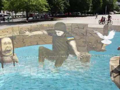 Der polnische 3D-K&uuml;nstler Gregor Wosik l&auml;sst angesichts des Krieges in der Ukraine symbolisch eine wei&szlig;e Friedenstaube fliegen. Aziz Elgart sowie das Vater-Tochter-Gespann Melina und Wilfried Berg haben beim gro&szlig;en Bild geholfen.