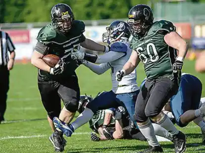 Blockarbeit: Alex Hartwig (rechts, Nummer 60) bei einem Laufspielzug &ndash; zu seinen Aufgaben geh&ouml;rt speziell der Schutz des Quarterbacks.
