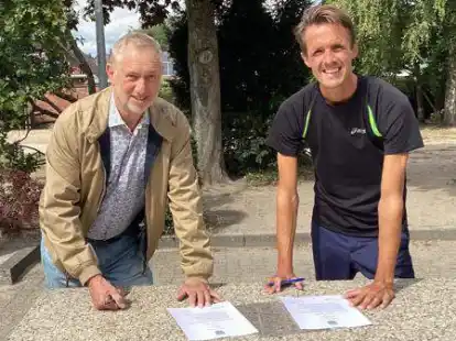 Der Vorsitzende des Heidm&uuml;hler FC Reinhold Fischer (links) und der Schulleiter der Grundschule Oestringfelde Stephan Immega unterzeichnen die Kooperationsvereinbarung.