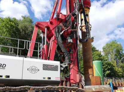 Mit diesem Gro&szlig;ger&auml;t werden die L&ouml;cher in der Baugrube f&uuml;r den Neubau des Klinikums in den Boden gebohrt. Im Vordergrund sind bereits versenkte Mikropf&auml;hle zu erkennen.