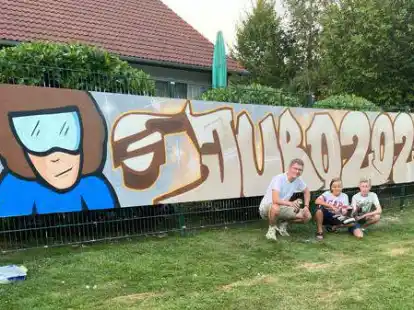 Tobias Meyer alias &bdquo;Zwick&ldquo; (von links) gemeinsam mit Jaron Legenhausen und Jesse Seebert beim Graffiti-Workshop im Garten des Bockhorner Jugendzentrums. Das gro&szlig;e Motiv war das Abschlussprojekt des Workshops, bei dem alle Teilnehmer selbst zur Spr&uuml;hdose greifen durften.