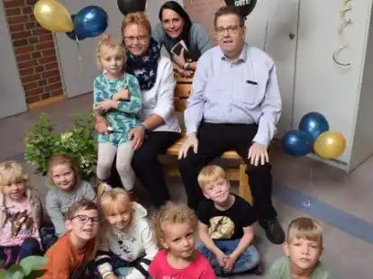 Feierlicher Abschied: Maria Bohnen (sitzend links) wurde von den Kindern, Kollegen sowie von Kindergarten-Leiterin Liane Meyer (Mitte) und Pfarrer Ludger Becker an ihrem letzten offiziellen Arbeitstag &uuml;berrascht.