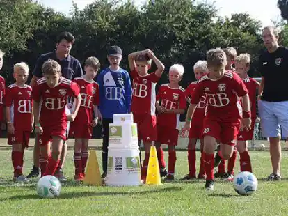 Von der Sportstation begeistert: die E-Junioren der SG Friedrichsfehn/Petersfehn und ihr Trainer Nils Raddatz (rechts). Wolfgang Alexander Paes (links) hat das Ger&auml;t entwickelt.