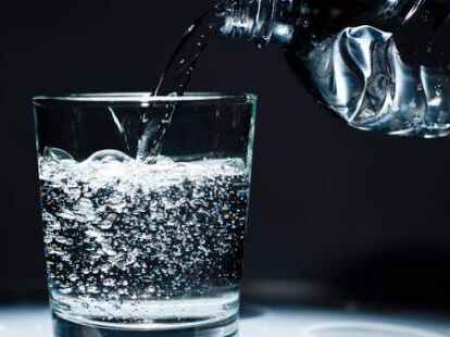 Ein Glas wird mit Mineralwasser befüllt. Ein Mangel an Kohlensäure bremst deutsche Brauer und Mineralwasserhersteller aus.