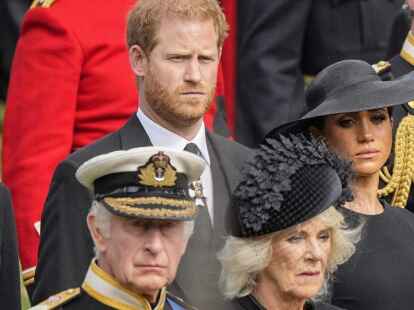 Westminster: Der britische König Charles III, von unten links, Camilla, die Queen Consort, Prinz Harry und Meghan, Duchess of Sussex, sehen zu, wie der Sarg von Queen Elizabeth II nach der staatlichen Trauerfeier  in den Leichenwagen gelegt wird.
