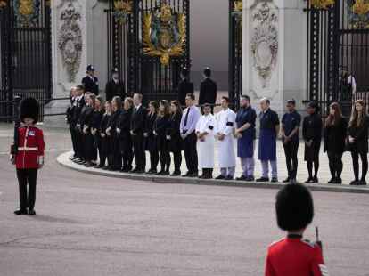 London: Mitarbeiter des Buckingham Palace stehen während der Trauerfeierlichkeiten von Königin Elizabeth II. vor seinen Toren.