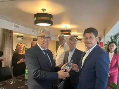 Feierstunde in Polen angesichts der 25-j&auml;hrigen Freundschaft zwischen Apen und Gizalki: Hans-J&uuml;rgen Janssen, stellvertretender Aper B&uuml;rgermeister (vorn links), erhielt von Robert Loza, dem B&uuml;rgermeister aus Gizalki (vorn rechts), als Geschenk eine Glasskulptur.