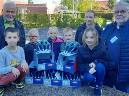 Helme f&uuml;r die Drittkl&auml;ssler Emil (von links), Jara, Lotta, Janno und Elly mit Sch&uuml;lerpraktikantin Naike Donk &uuml;berreichten Werner L&uuml;hrs und Bernd-Rainer Otten (rechts) von der Verkehrswacht Jeverland.