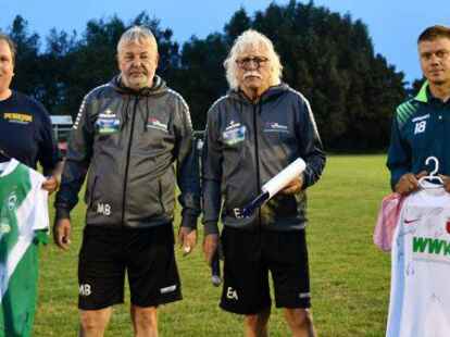 Eike H&ouml;cker (links) und Manuel Memenga (rechts) holen die Trikots von Werder Bremen und dem FC Augsburg ab: Die Ostfriesland-Cup-Macher Manfred Bloem und Ewald Adden hatten die Versteigerung angeschoben.