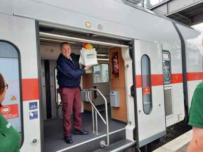 H&auml;lt stolz sein Pr&auml;sent hoch: Zugchef Claus Heeren, kurz vor der Abfahrt.