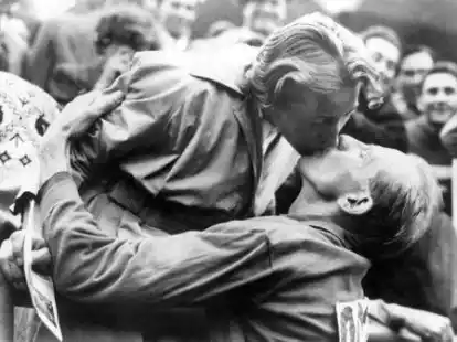 Emil Zatopek, der frischgebackene Olympiasieger im Marathonlauf, gibt kurz nach dem &Uuml;berqueren der Ziellinie seiner Frau Dana Zatopkova einen Kuss. Foto: -/dpa