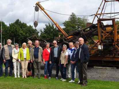 Die Gruppe der Stammtischgesellschaft &bdquo;Getreue von Jever&ldquo; vor einer riesigen Maschine, die den Torf abbaute.