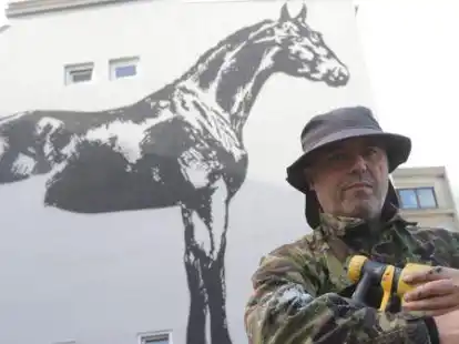 Urban Art K&uuml;nstler Victor Ash vor dem fast fertigen Kunstwerk.