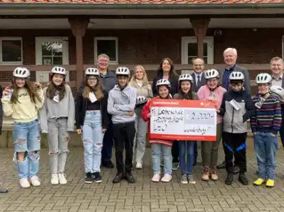 Kostenlose Fahrradhelme f&uuml;r die Sch&uuml;lerinnen und Sch&uuml;ler: M&ouml;glich machen das Detlef Kohlwey (hinten, von links), Emily Blanke und Elisabeth Devalle von Labom, Carsten Kahnert, Gerd Behrens, Christian Pundt vom Landkreis und Schulleiterin Anna Weers.