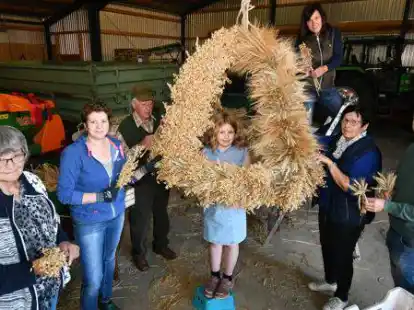 Auf dem Hof Schwarting haben (von links) Thea Brinkmann, Tanja, Rudolf und Leevke Schwarting sowie Frauke Gaede, Hella Wiese und Onno Osterloh die Erntekrone des Ortslandvolks gebunden.