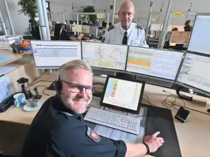 H&ouml;ren zu und reagieren, wenn 110 gew&auml;hlt wird: Claas Jan&szlig;en (vorne) aus der Leitstelle der Polizei und J&ouml;rg Bokelmann (Leiter Einsatzmanagement) an ihrem Arbeitsplatz.