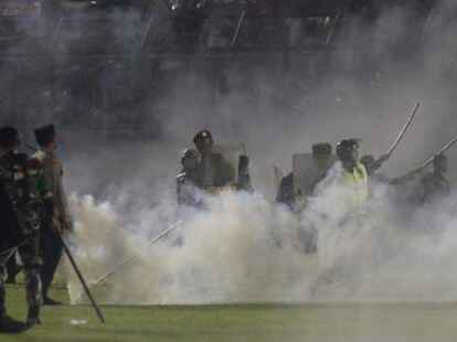 Polizisten und Soldaten stehen inmitten von Tr&auml;nengasrauch bei einem Erstliga-Spiel zwischen Arema FC und Persebaya FC. Bei schweren Ausschreitungen im Anschluss an ein Fu&szlig;ball-Spiel in der indonesischen Provinz Ost-Java sind mindestens 174 Menschen ums Leben gekommen.