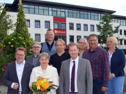B&auml;rbel Nienaber (vorn mit Blumen) feierte ihr Dienstjubil&auml;um mit (von links): Carsten Meyer, Andreas Gronde, Axel Heyne, Wolfgang Piepenburg, B&uuml;rgermeister Henning Dierks, Sandra Ahlers, Christian Binder (Personalrat) und Cornelia Sch&uuml;rmann.