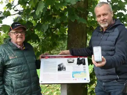 Heinrich Hallwa&szlig; (l.) und B&uuml;rgermeister Uwe Redenius zeigen die neue Informationstafel in Abbingwehr. Ein QR-Code auf der Tafel f&uuml;hrt via Smartphone zur Klostergeschichte.