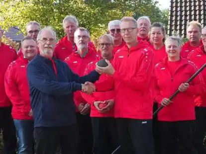 Mit neuen Outfits: Im Kreise der aktiven Bo&szlig;elerinnen und Bo&szlig;elern &uuml;bergibt der bisherige Vorsitzende Uwe Hollmann die Bo&szlig;elkugel an seinen Nachfolger Rainer Schneider.