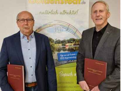 Autor Winfried R&ouml;tepohl-Bahlmann (l.) pr&auml;sentiert sein neuestes Buch B&uuml;rgermeister Alfred Kuhlmann (r.).