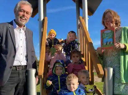 Mit Tiger, B&auml;r, G&uuml;nter Kastenfrosch und der Tigerente auf der Reise nach Panama: Initiator G&uuml;nter Marken und Kita-Leiterin Margret Budden freuen sich mit den Kindern dar&uuml;ber, dass die Kita &bdquo;Klein Bullerb&uuml;&ldquo; ein Exemplar von &bdquo;Oh, wat moi ist Panama&ldquo; bekommen hat.