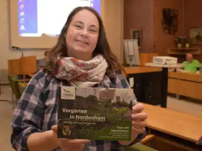 Grünen-Ratsmitglied Inga Lüdke zeigt die Broschüre, die Tipps für naturnahe Vorgärten gibt.