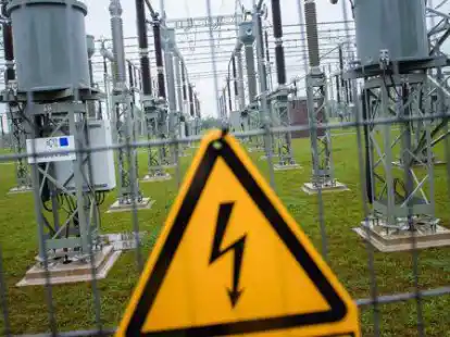 Eine Reihe von Sammelschienenmasten sind im Umspannwerk der Tennet  hinter einem Warnschild zu sehen.