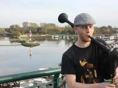 Hoch vom Aussichtsturm am Bar&szlig;eler Hafen erfreut Stefan  Abeln aus Harkebr&uuml;gge die Menschen mit seiner Dudelsack-Musik.