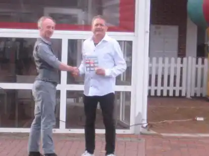 Henk Wolf (links) &uuml;bergibt Tiziano Marin das erste Exemplar der Brosch&uuml;re &uuml;ber Saterfriesisch f&uuml;r die Gastwirtschaft.