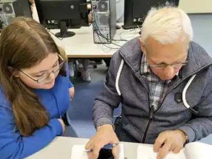 Sch&uuml;lerin Irena Wellenbrock erkl&auml;rte Heinz Meyer Funktionen am Smartphone.