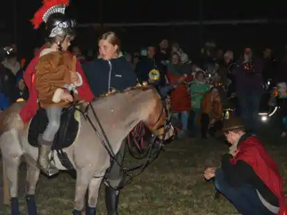Beim ersten &ouml;kumenischen St. Martinslauf in Schortens: St. Martin (gespielt von der siebenj&auml;hrigen Lilly Biber) hoch zu Ross teilt seinen Mantel mit einem armen Bettler.