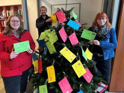 Wunschbaumaktion in Rastede (von links): Paulina Hybrant Johannes Brandmaier und Anne Ahlers-Bolting best&uuml;cken den Baum im Gemeindehaus am Denkmalsplatz.