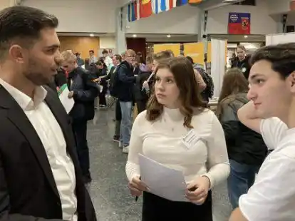 Von Azubi zu Sch&uuml;lern: Mohamed Edi Bashota (von links) berichtet Sarah Tellmann (15) und Musa Cicek (17) von seiner Ausbildung zum Versicherungskaufmann.