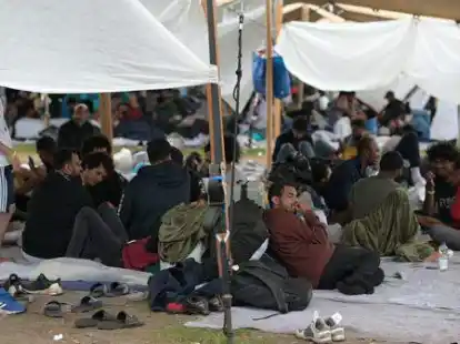 Asylsuchende verweilen in einem Asylzentrum, hier im Sommer in Ter Apel in den Niederlanden, an der Grenze zu Niedersachsen im Freien, aus Mangel an Schlafpl&auml;tzen.