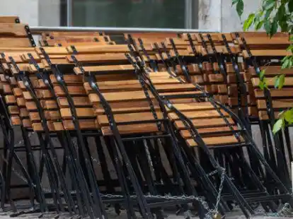 Schwere Zeiten: St&uuml;hle sind im Au&szlig;enbereich einer geschlossenen gastronomischen Einrichtung zusammengestellt und festgekettet worden. (Symbolbild)