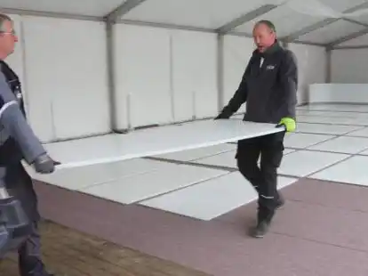 Mitarbeiter der Firma Glice und des st&auml;dtischen Bauhofs verlegten am Mittwoch die Kunststoffplatten der Nordenhamer Eisbahn. Ab Freitag kann dort Schlittschuh gelaufen werden.