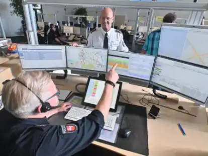 Koordinieren die Eins&auml;tze, die unter anderem durch Notrufe ausgel&ouml;st werden: Claas Jan&szlig;en (vorne) und Leiter J&ouml;rg Bokelmann, in der Leitstelle der Polizeidirektion am Friedhofsweg.