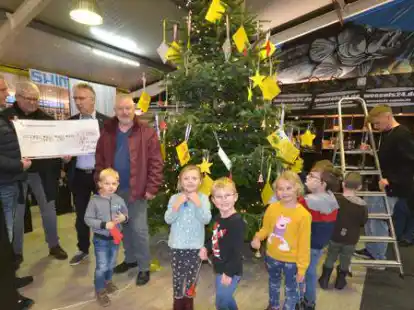 Heiko Kruse, Gerhard Barz und Egon Drees vom Gewerbeverein (v.l.) stellten den Wunschbaum mit Wunschzetteln in der Firma Wessels in Moordorf vor - und hatten f&uuml;r Tafel-Chef Christoph Meyer auch noch einen Scheck dabei. Die Kinder vom DRK-Kindergarten schm&uuml;ckten den Baum.