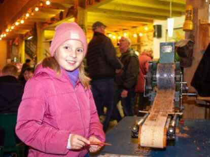 Die neunjährige Laura holte die Spekulatius-Rohlinge vom Mini-Band der handbetriebenen Maschine.