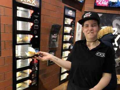 Arbeitet mit Freude beim Automatenbetrieb „Hotboxxx“ in Hannover:  Joy Alexandra Krieg zieht einen Snack hinter der Klappe hervor.