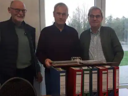 Sechs dicke Ordner voll mit der Vereinschronik und noch zwei mit Bildern zum Kunstrasenplatzbau: TuS-Gesch&auml;ftsf&uuml;hrer Helmut Kohle und die beiden Chronik-Erfasser Johann Alberts und Dieter Harberts.