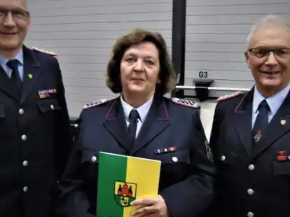 Gemeindebrandmeister Torsten Schattschneider (links) bef&ouml;rderte die Gemeindepressewartin Ria Meinardus (Mitte), Feuerwehr R&uuml;dershausen, zur Oberl&ouml;schmeisterin. Rechts im Bild der stellvertretende Gemeindebrandmeister Holger Dwehus.