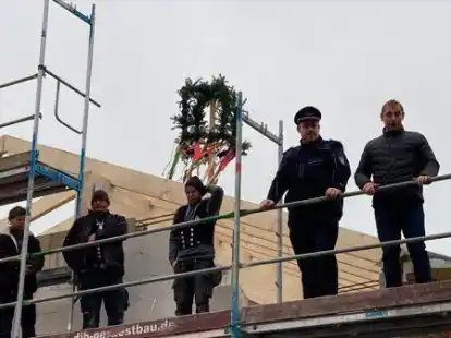 Beim Feuerwehr-Richtfest in Hollen: Uplengens B&uuml;rgermeister Heinz Trauernicht (r.), Ortsbrandmeister Thorsten Engels und Mitarbeiter der Dachdecker-Firma Stefan B&uuml;nting.