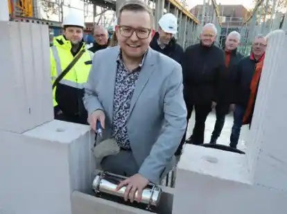 B&uuml;rgermeister Nils Anhuth mauerte die Rohrh&uuml;lse, die mehrere Zeitgegenst&auml;nde enth&auml;lt, ein. Aufmerksame Beobachter waren die Mitglieder des Bauausschusses, die Architekten und der Bauleiter.