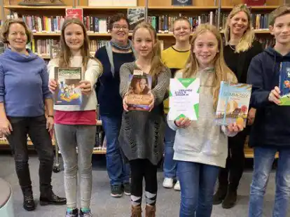 Haben Spa&szlig; am Lesen: Schulentscheid-Gewinnerin Rieke Hartmann (Mitte, vorne) mit den Klassengewinnern (vorne) und der Jury (hinten). (Vorne, von links): Carlotta Begert aus der 6d, Sophia Winter aus der 6a, Rieke Hartmann aus der 6e und Tom Fiebig aus der 6c. (Hinten, von links): Deutschlehrerin Mareke Toben, Claudia Hoffmann von der B&uuml;cherstube, Lily Schlalos vom Bundesfreiwilligendienst und Bibliotheksleiterin Dr. Anja Belemann-Smit.