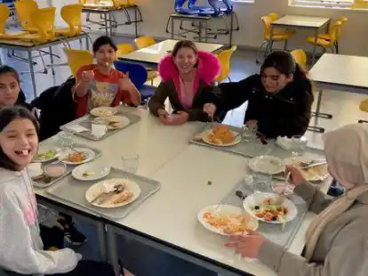 Damen hoch f&uuml;rs Mensaessen in der Oberschule Borssum: Diesen Sch&uuml;lerinnen schmeckt, was ihnen Udo van Scharrel als Mittagessen anbietet.